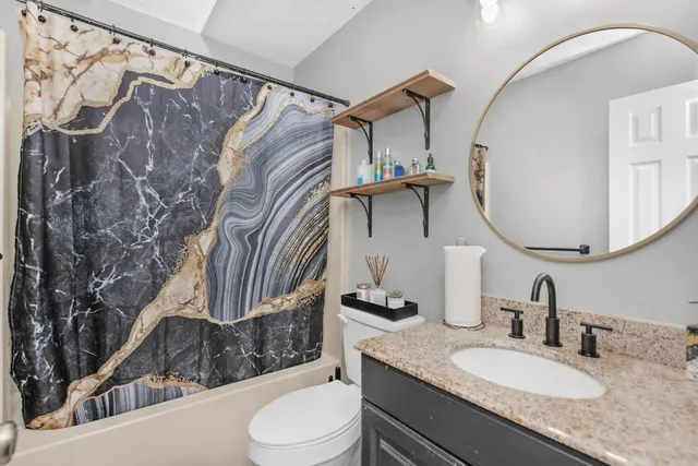 a bathroom with a sink toilet and shower