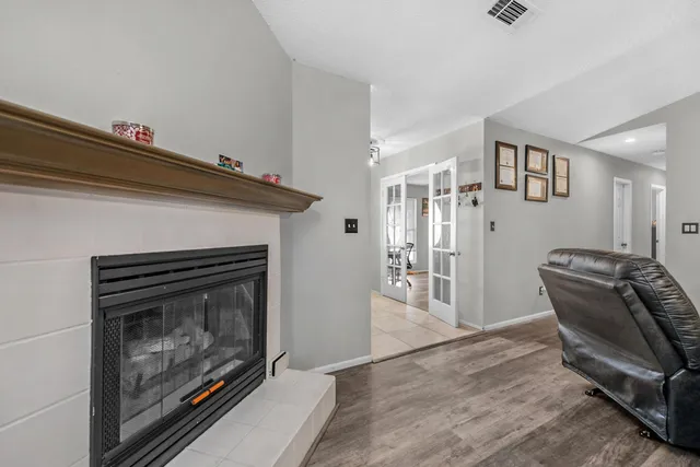 a kitchen with stainless steel appliances granite countertop a stove top oven a sink a dining table and chairs with white cabinets