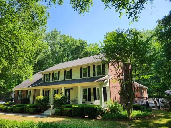 a front view of a house with a yard and green space