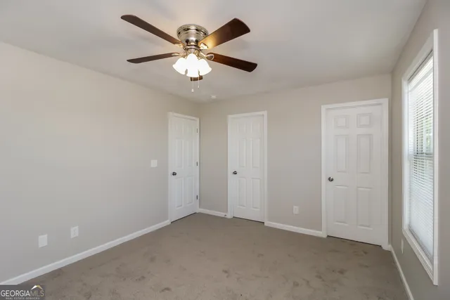 an empty room with chandelier fan