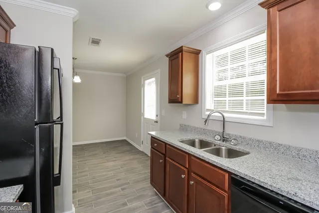 a kitchen with stainless steel appliances granite countertop a sink and a refrigerator