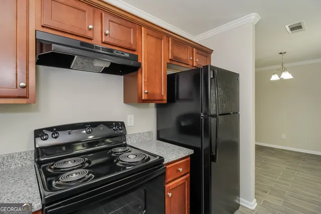 a kitchen with stainless steel appliances granite countertop a refrigerator and a stove top oven