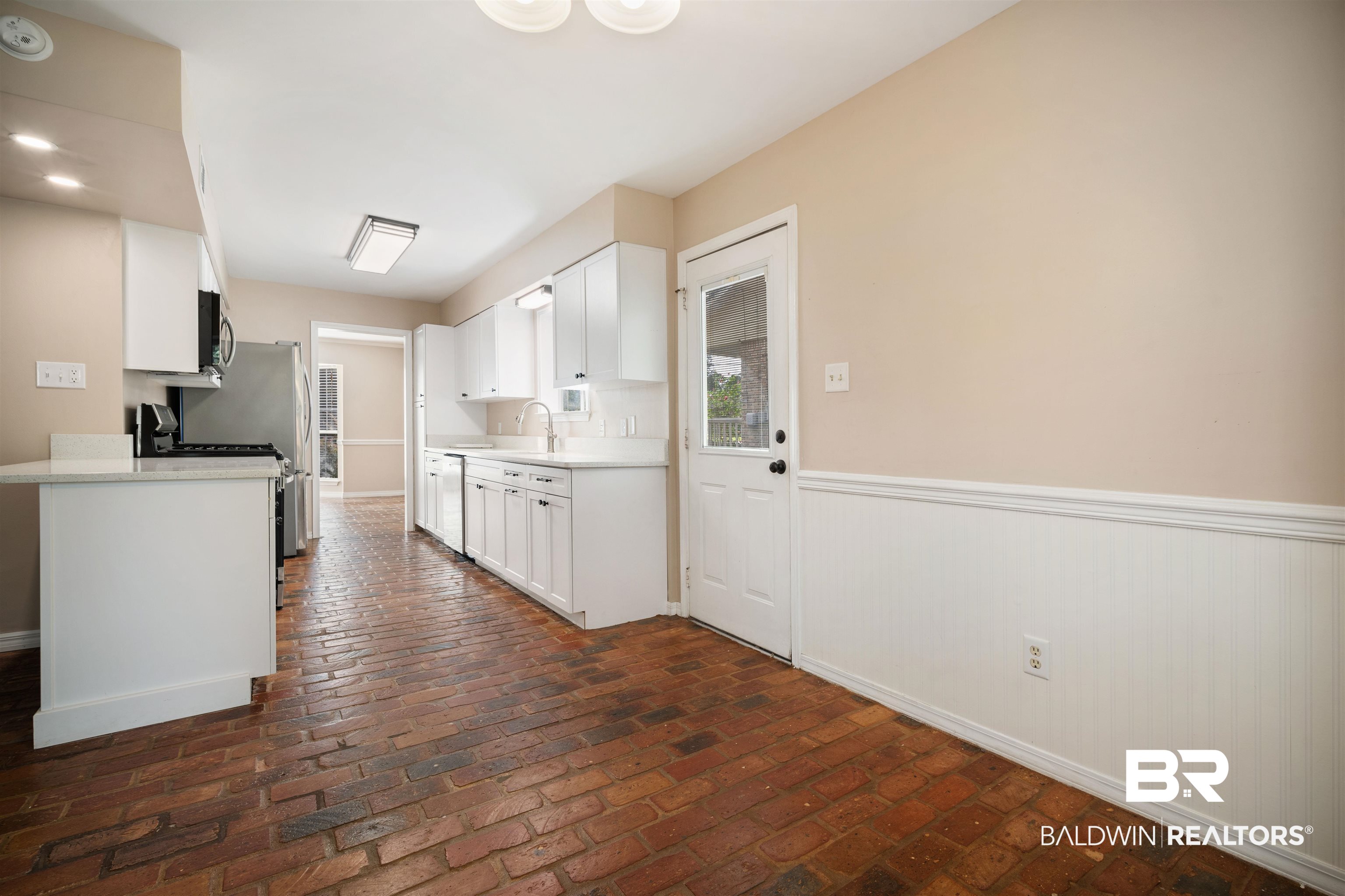 804 Wildwood Avenue Mobile, AL 36609 - Photo 12 of 30 Kitchen featuring white cabinetry, gas range, and sink