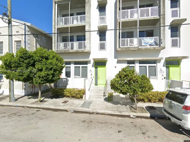 a view of a building with a yard and large windows