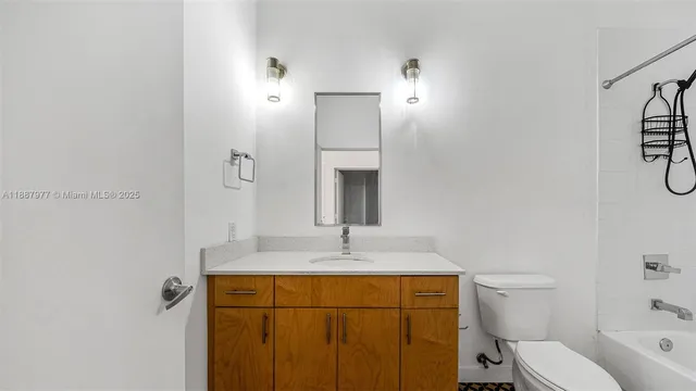 a bathroom with a granite countertop sink toilet and mirror