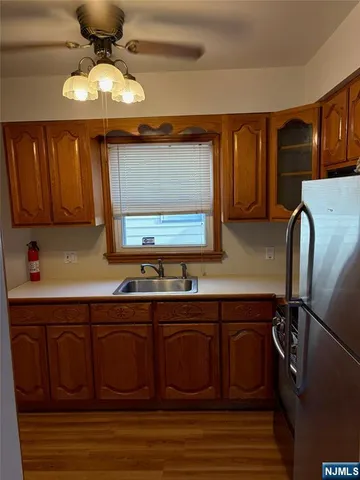 a kitchen with stainless steel appliances a sink cabinets and wooden floor