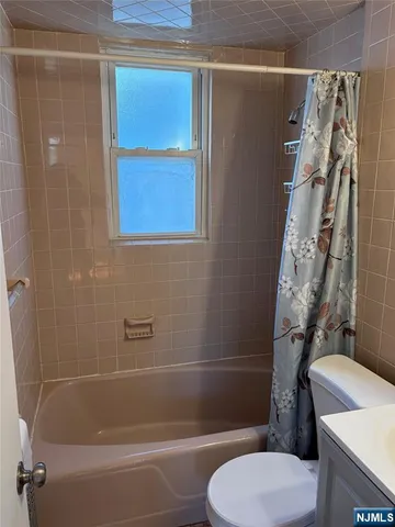 a white toilet sitting next to a bath tub and shower