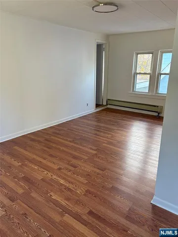 a view of a room with wooden floor and windows