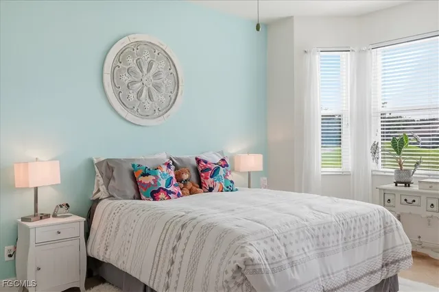 a bedroom with a bed and a lamp on dresser