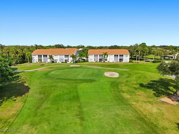 a view of a big house with a big yard and large trees