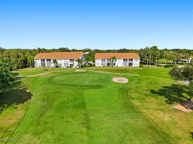 a view of a big house with a big yard and large trees