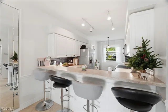 a kitchen with granite countertop a sink and a stove with chairs