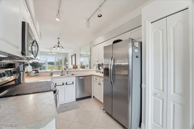 a kitchen with stainless steel appliances granite countertop a refrigerator a sink a stove and a refrigerator