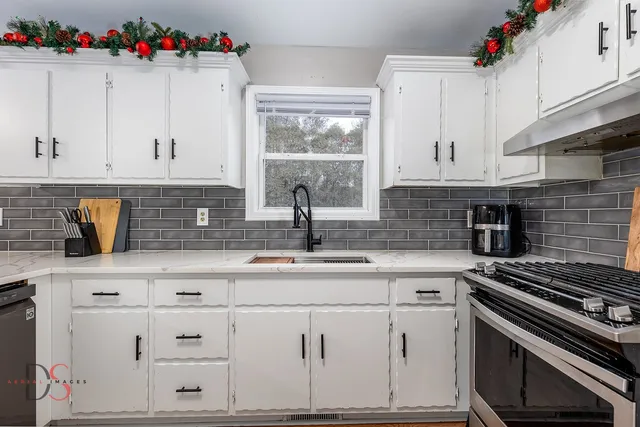 a kitchen with granite countertop a sink stainless steel appliances and cabinets