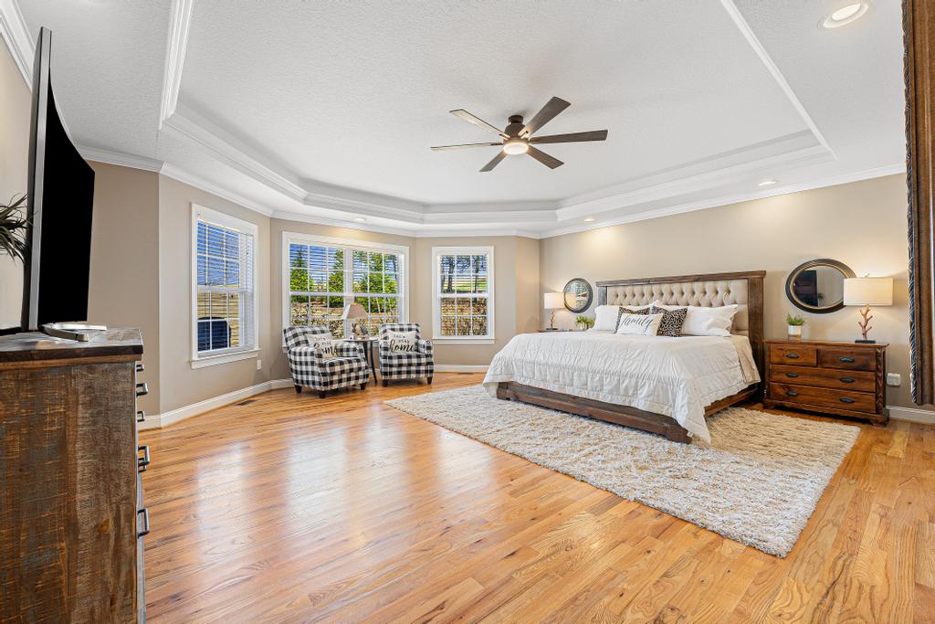 604 Feathery Lane Seneca, SC 29678 - Photo 21 of 44 This spacious primary bedroom features rich hardwood flooring and a ceiling fan, creating an inviting retreat.