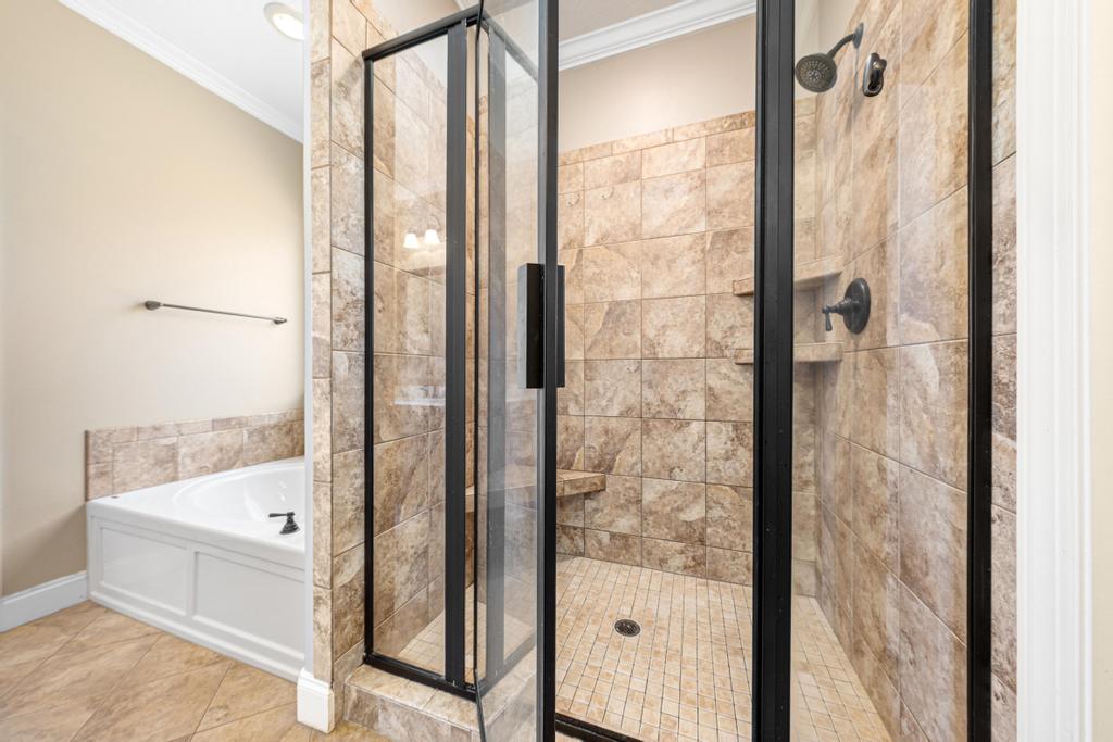 604 Feathery Lane Seneca, SC 29678 - Photo 24 of 44 This bathroom features a sleek glass-enclosed shower alongside a pristine built-in soaking tub.