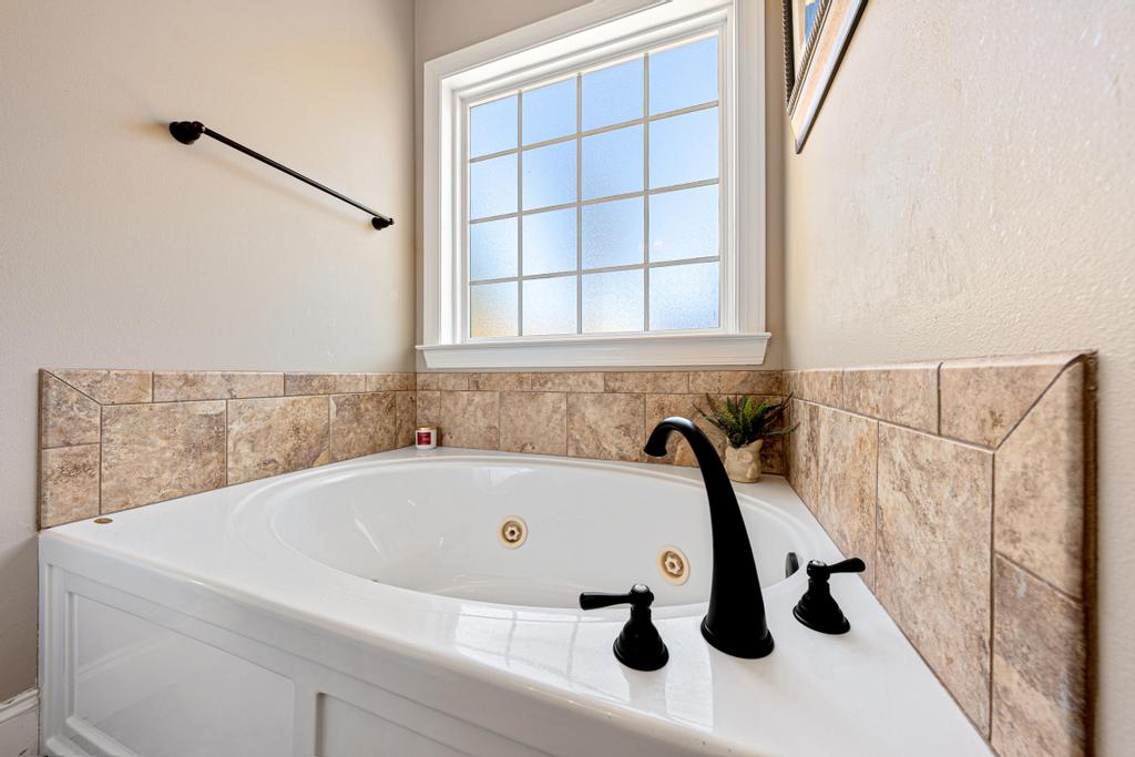 604 Feathery Lane Seneca, SC 29678 - Photo 25 of 44 Relax in this tranquil corner soaking tub, complete with elegant black fixtures and tiled surround.