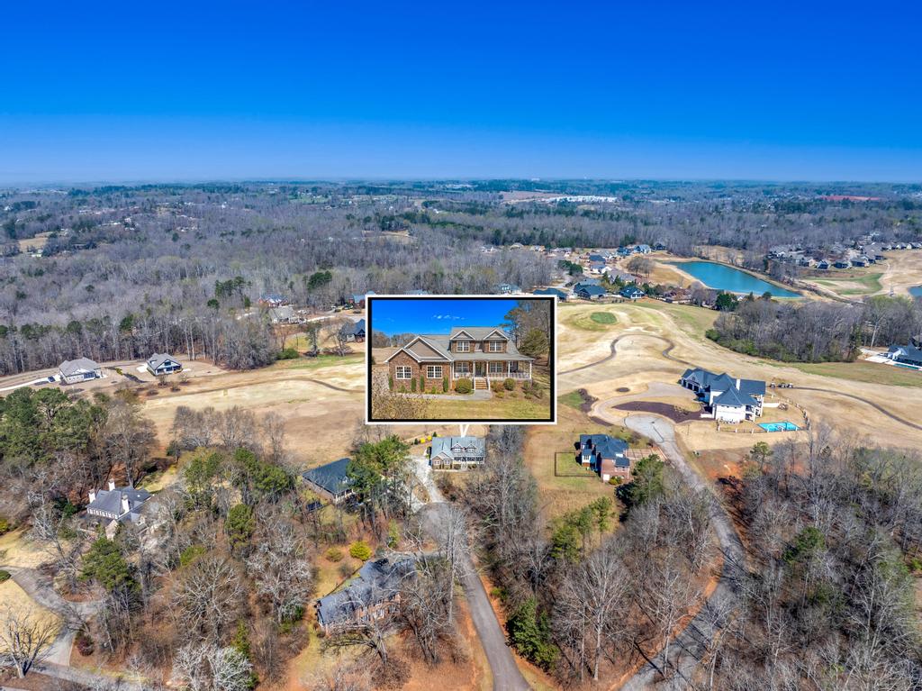 604 Feathery Lane Seneca, SC 29678 - Photo 36 of 44 This aerial view showcases a residential property nestled amidst lush greenery and a serene pond.