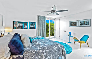 2649 Kings Road West Palm Springs, CA 92264 - Photo 38 of 50 a spacious bedroom with a bed a chandelier and a large window