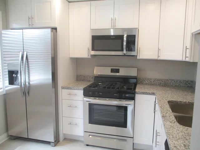 a kitchen with stainless steel appliances granite countertop a stove microwave and refrigerator