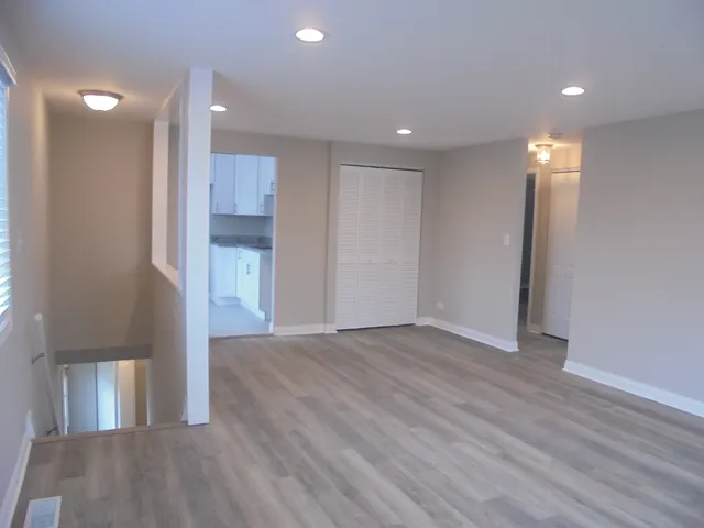a view of empty room with wooden floor