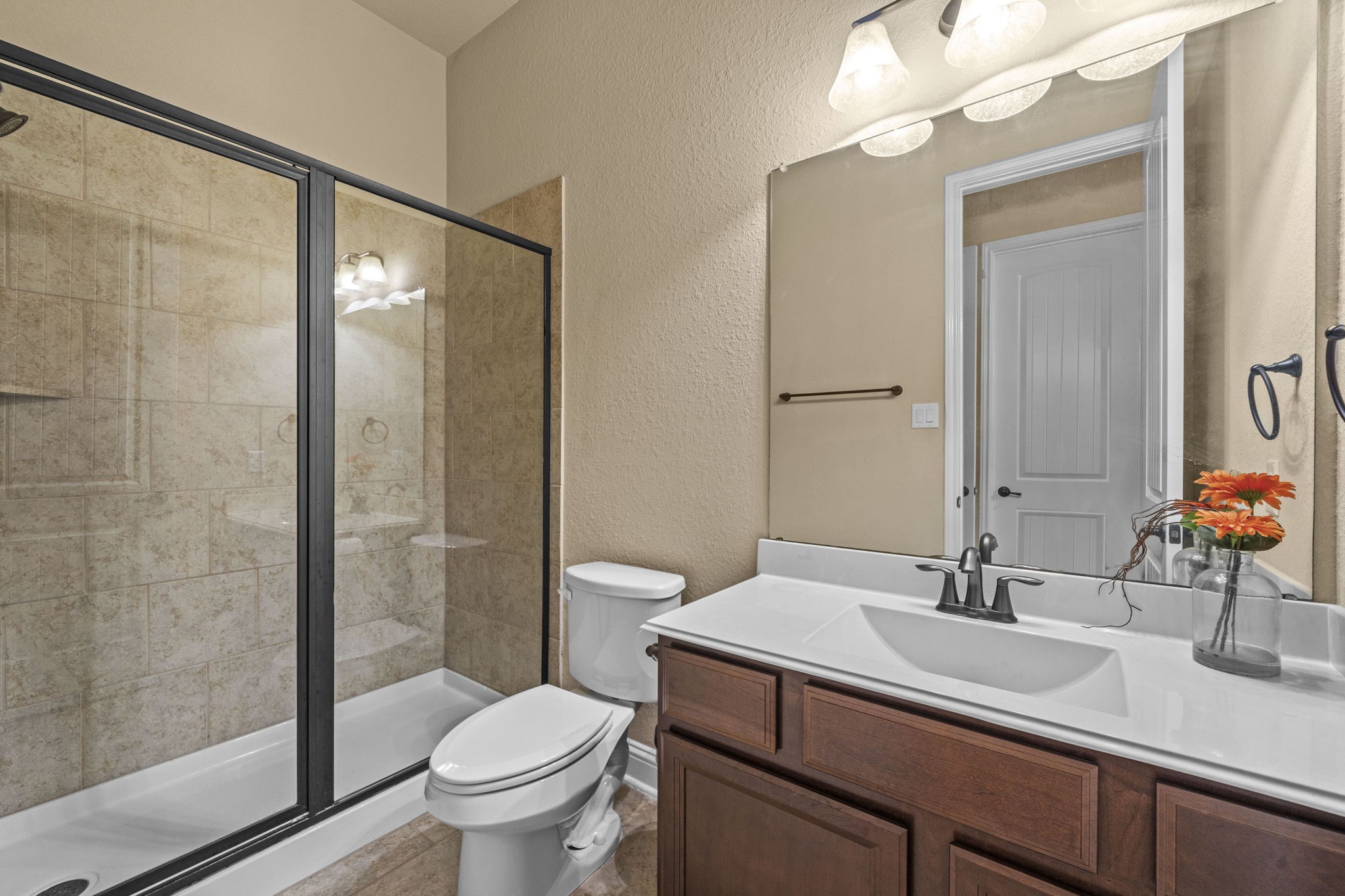 14215 Spindle Arbor Road Cypress, TX 77429 - Photo 39 of 47 This bathroom features a modern glass-enclosed shower with tile walls, a sleek vanity with a large mirror, and a bright, clean design.