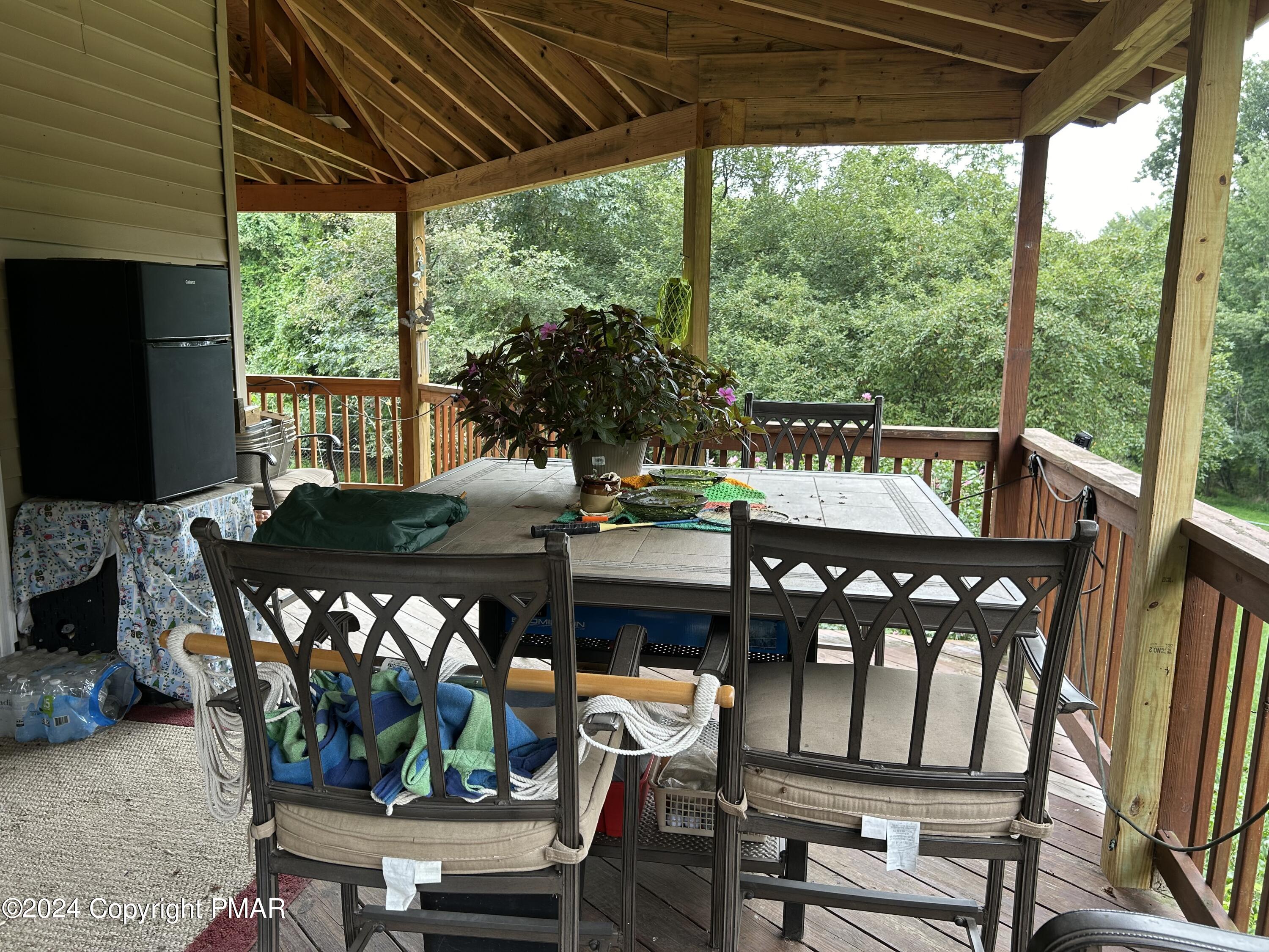 234 Shiffer Road Stroudsburg, PA 18360 - Photo 6 of 14 a view of a patio with table and chairs under an umbrella with a small yard