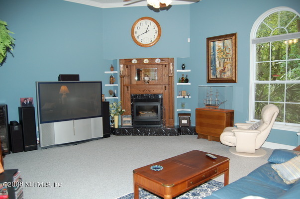 12819 Mandarin Road Jacksonville, FL 32223 - Photo 2 of 18 a living room with furniture a fireplace and a flat screen tv
