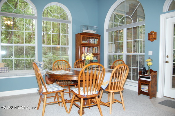 12819 Mandarin Road Jacksonville, FL 32223 - Photo 4 of 18 a dining room with furniture a chandelier and wooden floor