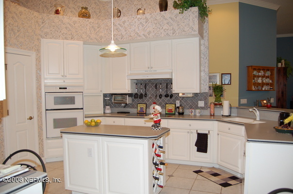 12819 Mandarin Road Jacksonville, FL 32223 - Photo 5 of 18 a kitchen with a sink a stove and white cabinets