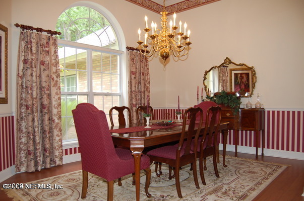 12819 Mandarin Road Jacksonville, FL 32223 - Photo 8 of 18 a view of a dining room with furniture a chandelier and wooden floor