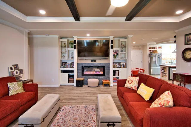 a living room with furniture a flat screen tv and a fireplace