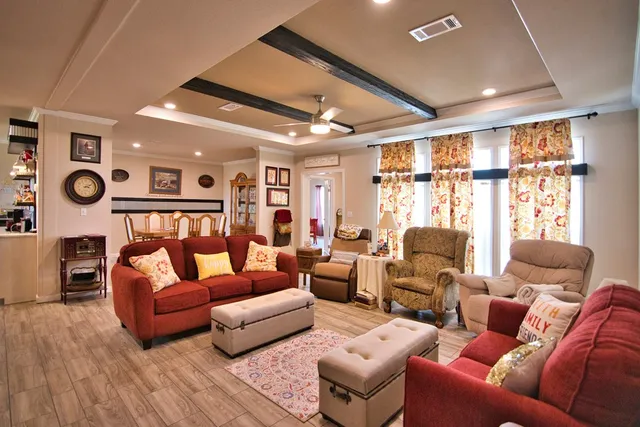 a living room with furniture a ceiling fan and a large window