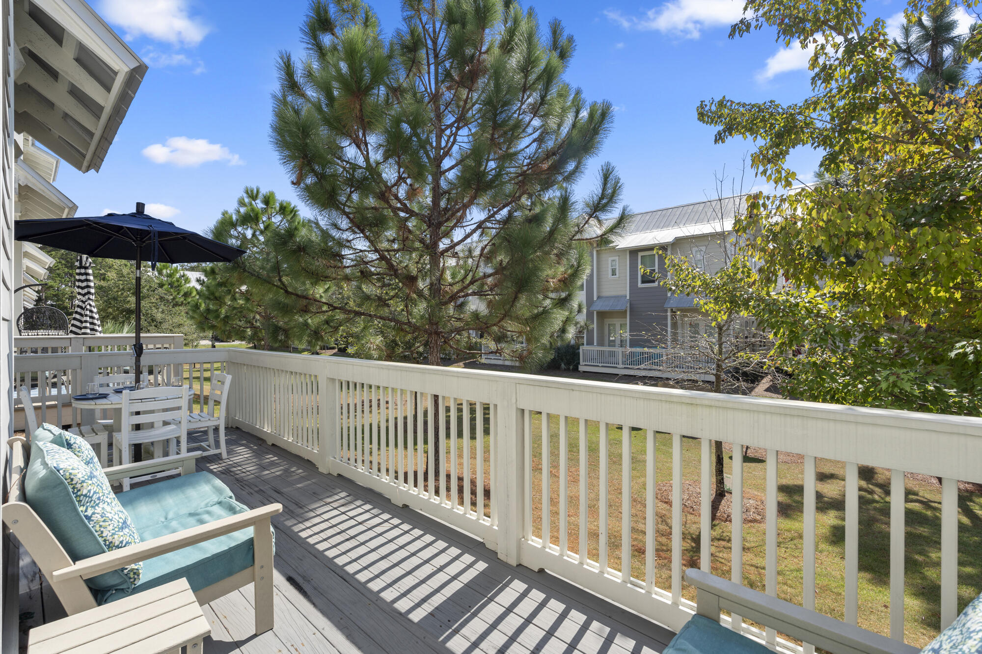 296 Milestone Dr Inlet Beach, Unit A Inlet Beach, FL 32461 - Photo 25 of 41 a balcony with wooden floor and outdoor seating