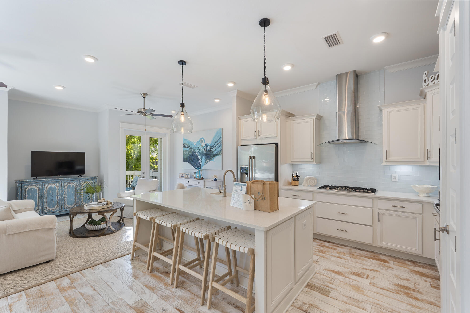 296 Milestone Dr Inlet Beach, Unit A Inlet Beach, FL 32461 - Photo 3 of 41 a large kitchen with kitchen island granite countertop a stove a sink a dining table and chairs with wooden floor
