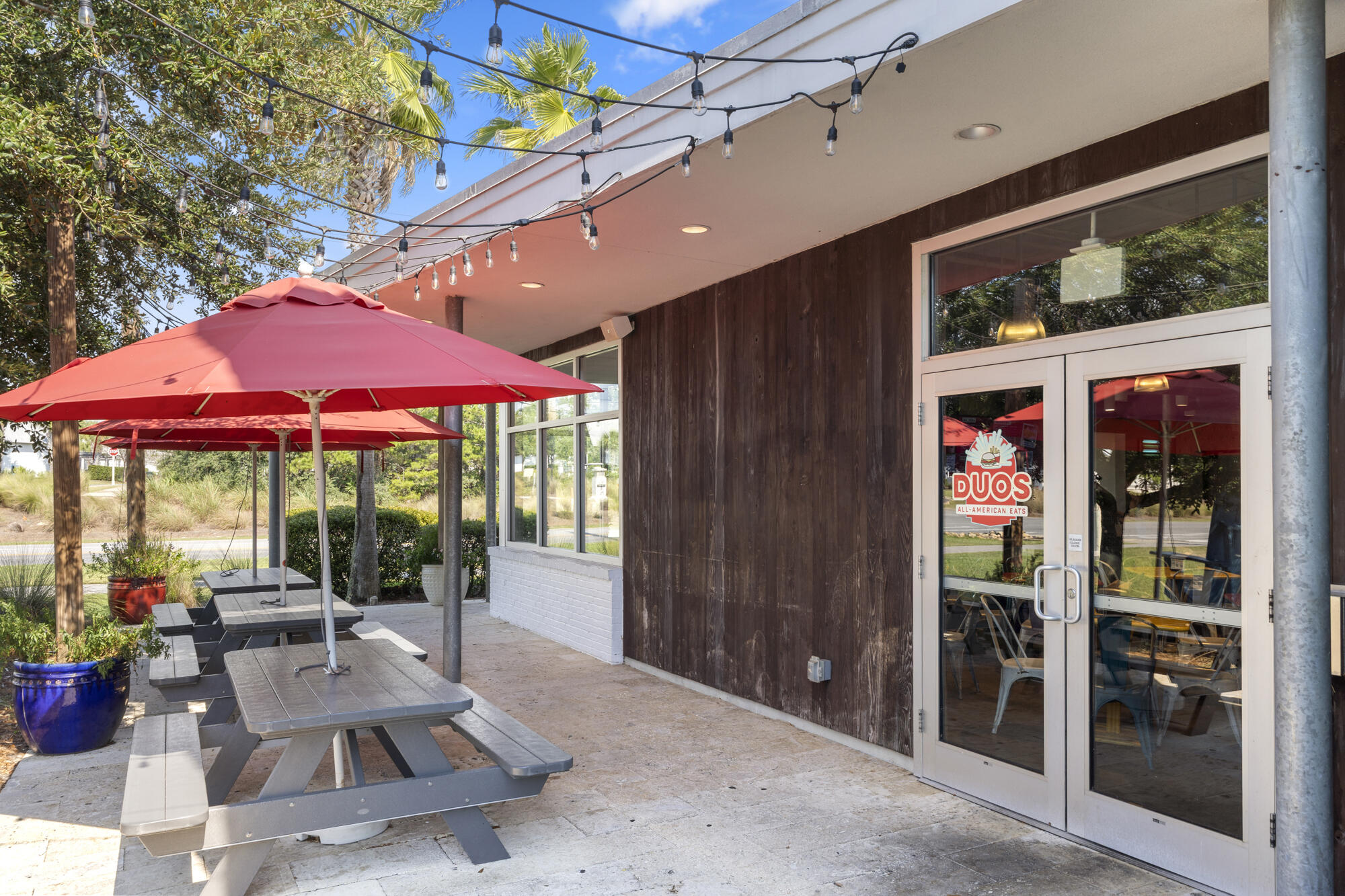296 Milestone Dr Inlet Beach, Unit A Inlet Beach, FL 32461 - Photo 35 of 41 a view of a patio with a table and chairs under an umbrella