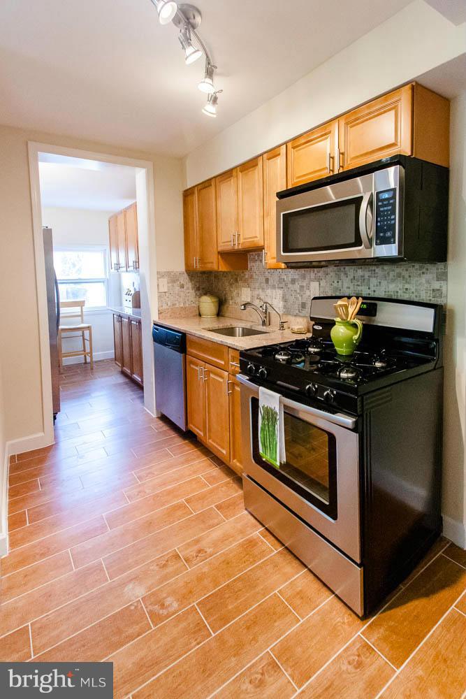 106 South Glebe Road Arlington, VA 22204 - Photo 11 of 28 a kitchen with stainless steel appliances granite countertop a stove and a microwave