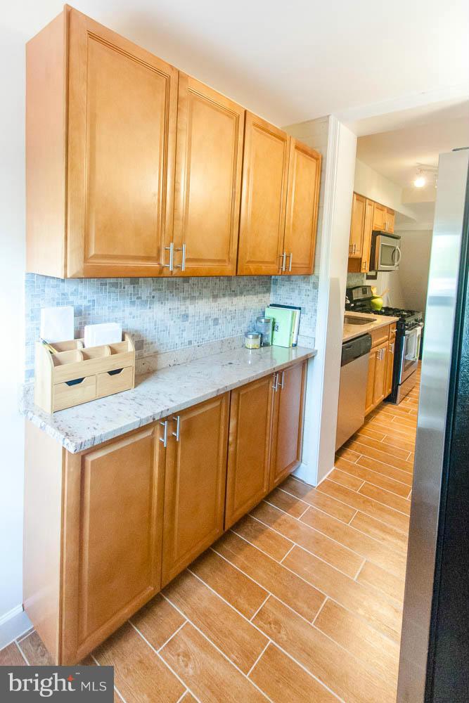 106 South Glebe Road Arlington, VA 22204 - Photo 13 of 28 a kitchen with stainless steel appliances granite countertop a sink and cabinets