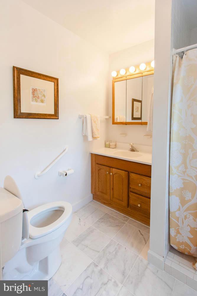 106 South Glebe Road Arlington, VA 22204 - Photo 14 of 28 a bathroom with a toilet a sink and mirror