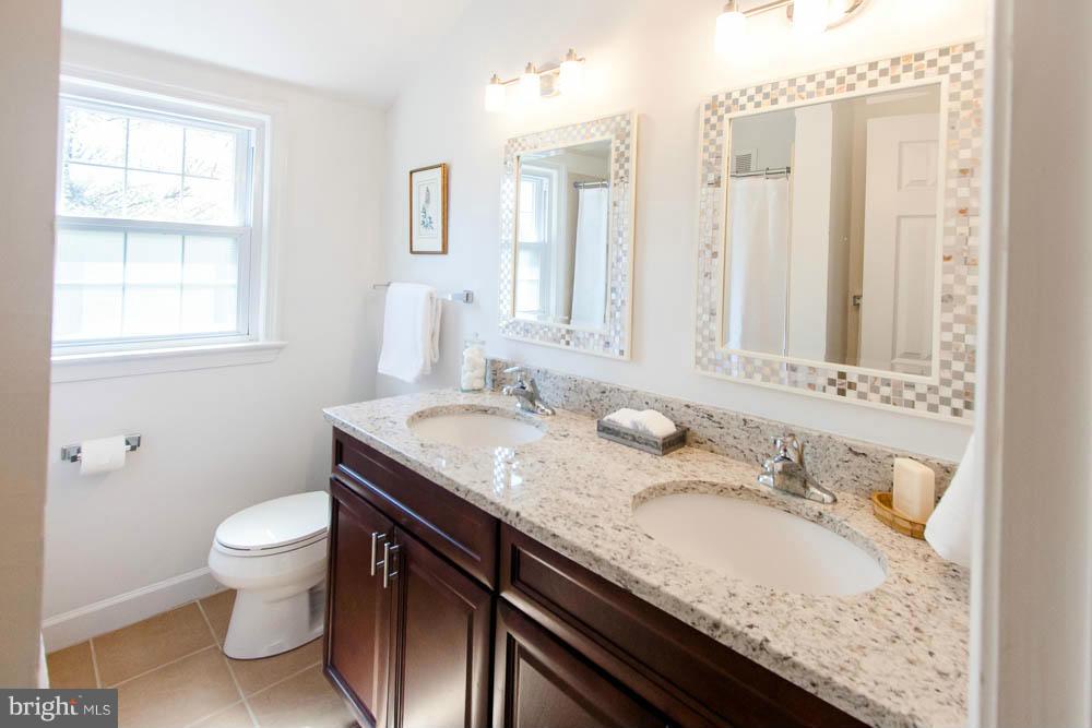 106 South Glebe Road Arlington, VA 22204 - Photo 20 of 28 a bathroom with a granite countertop sink a toilet and a mirror