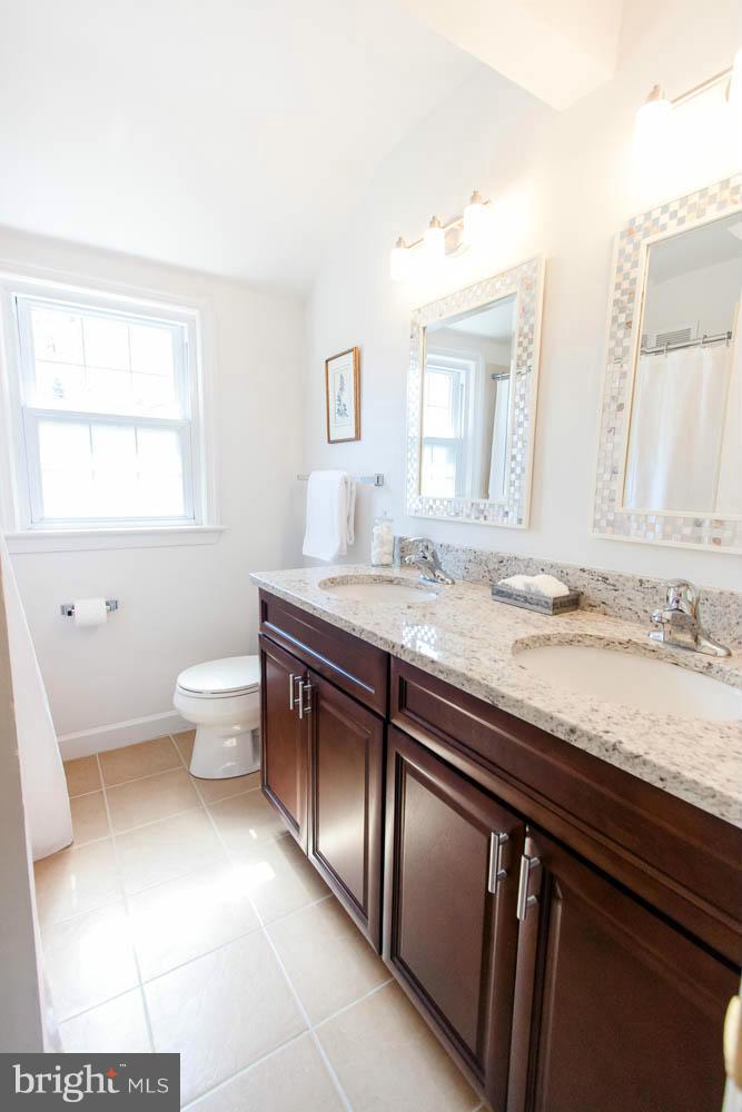 106 South Glebe Road Arlington, VA 22204 - Photo 21 of 28 a bathroom with a granite countertop sink a toilet and a mirror