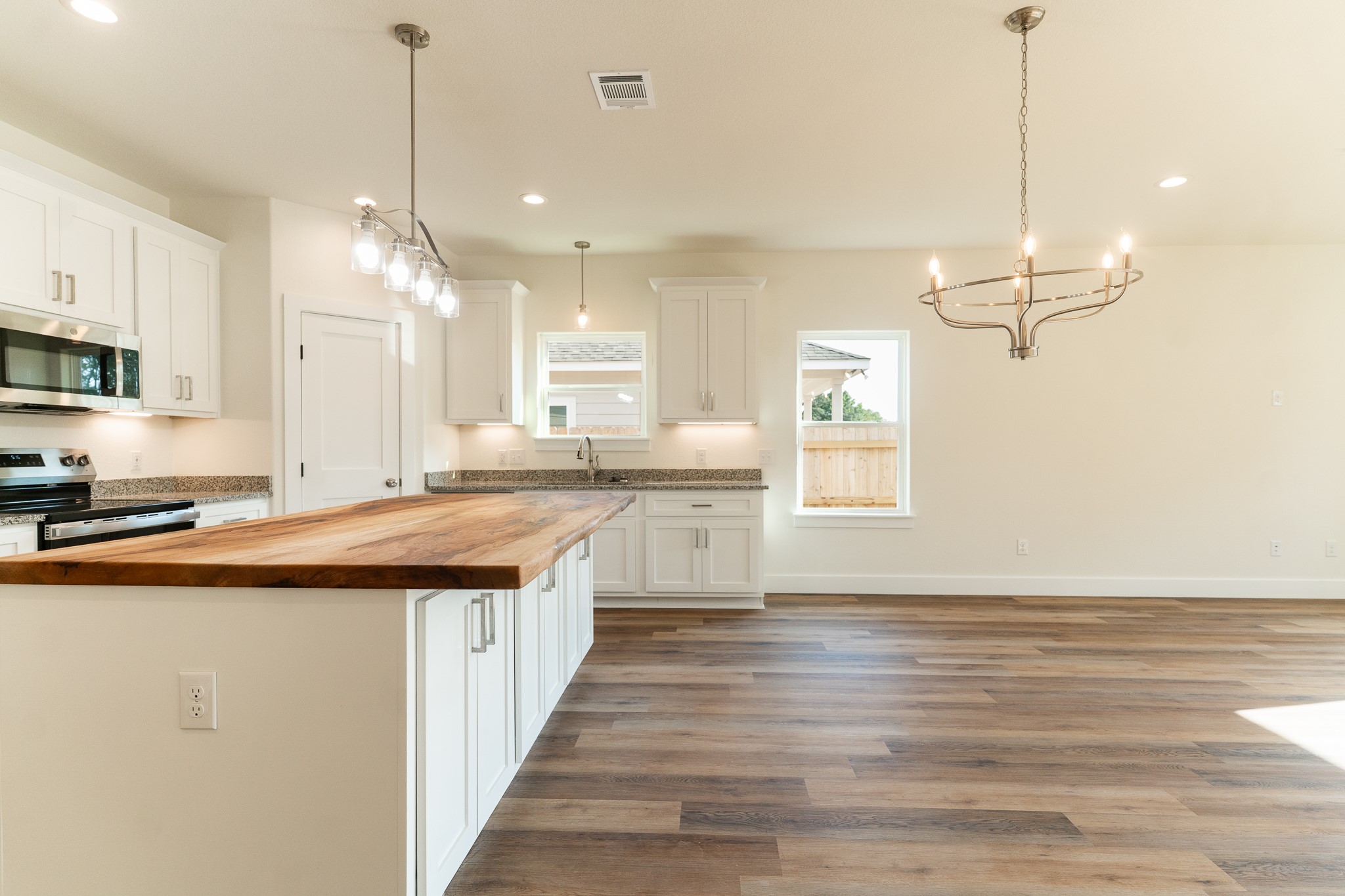 309 String Prairie Way Smithville, TX 78957 - Photo 6 of 30 a kitchen with stainless steel appliances granite countertop a sink stove and a wooden floor