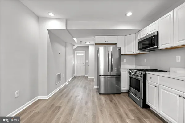 a kitchen with stainless steel appliances granite countertop a stove a refrigerator and a microwave