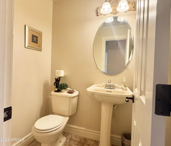 a bathroom with a toilet a sink and mirror