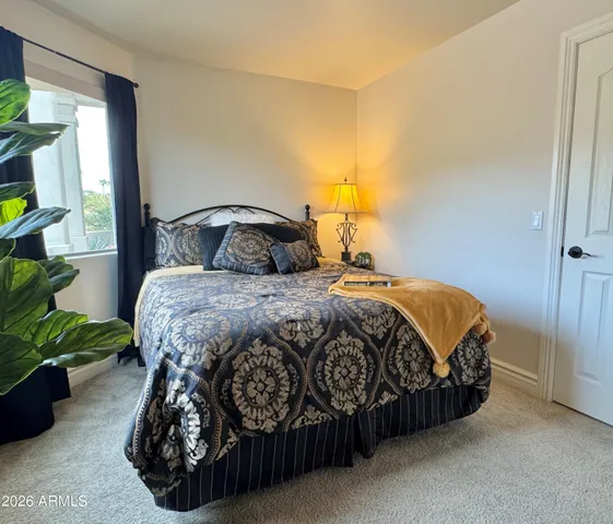 a bedroom with a bed lamp and a potted plant