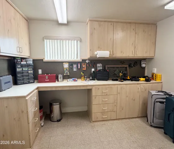 a kitchen with white cabinets and sink