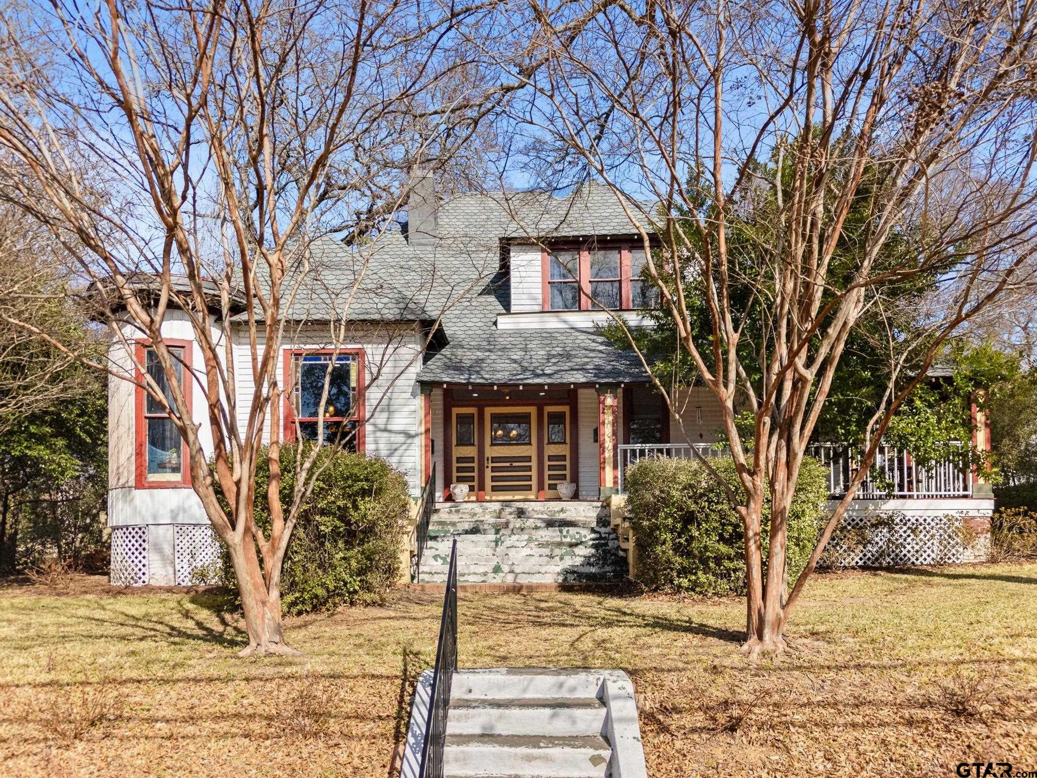 a front view of a house with a tree