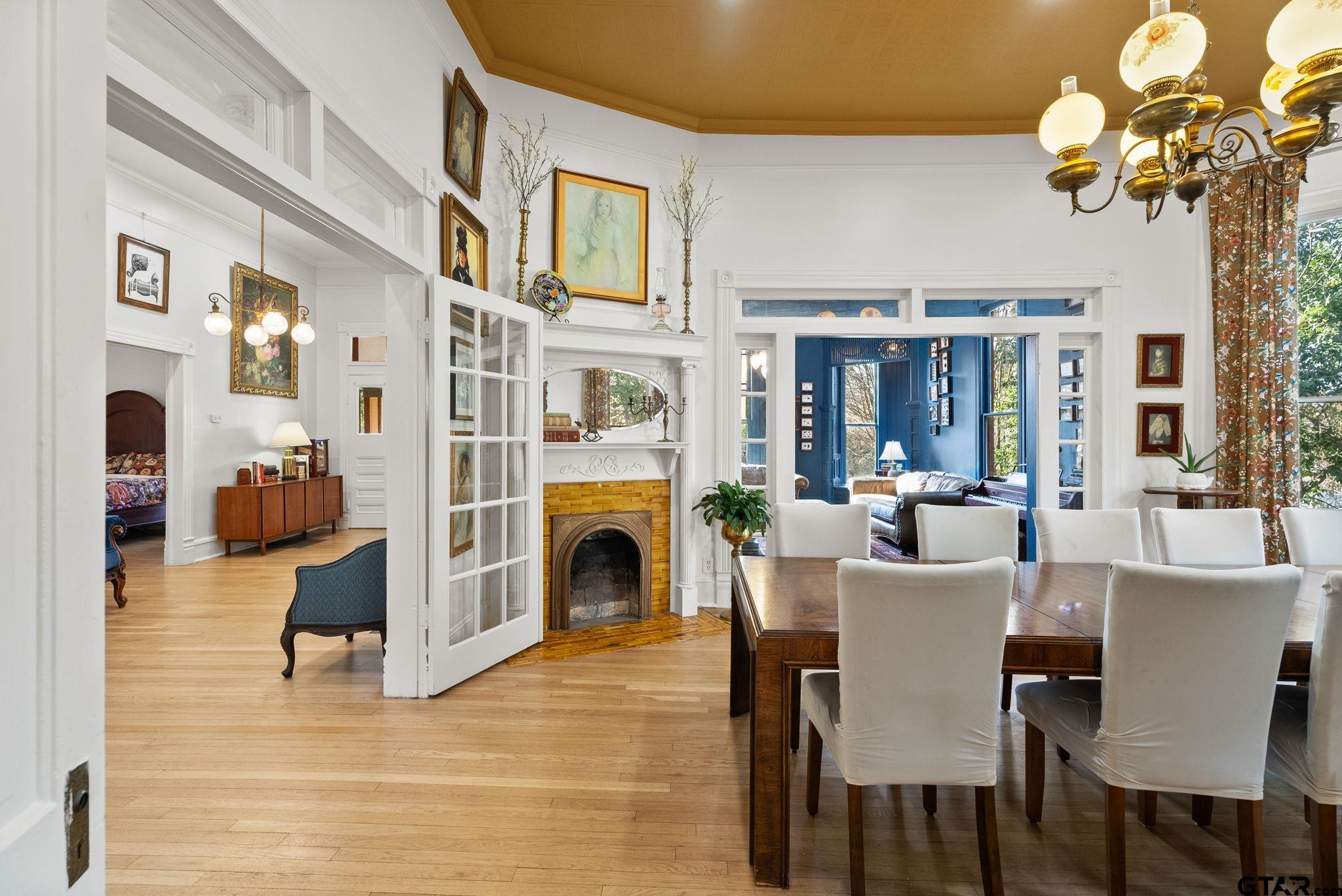 911 West Houston Street Tyler, TX 75702 - Photo 15 of 48 a view of a dining room with furniture a fireplace and chandelier