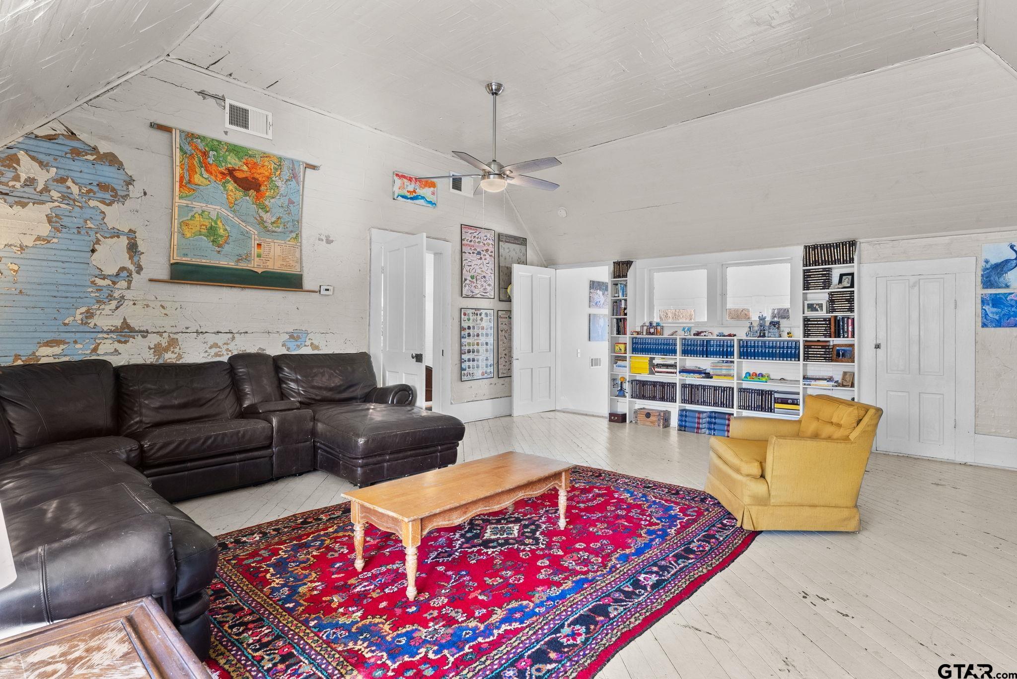 911 West Houston Street Tyler, TX 75702 - Photo 31 of 48 a living room with furniture a rug and a book shelf