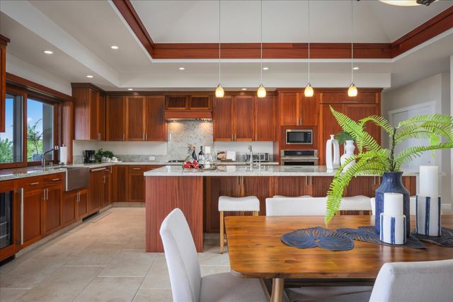 a room with stainless steel appliances kitchen island granite countertop a table and chairs in it
